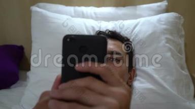 男人在床上放松，在智能手机上阅读，近距离，稳定<strong>射击</strong>，休闲活动，跟踪<strong>射击</strong>，手机